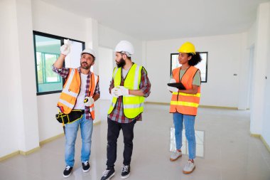 Kapılarda. Profesyonel Makine Mühendisi Ekibi, inşaat sahasının altındaki imalat fabrikasında güvenlik kaskı takıyor..