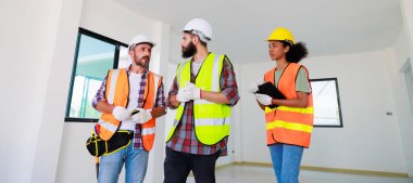 Kapılarda. Profesyonel Makine Mühendisi Ekibi, inşaat sahasının altındaki imalat fabrikasında güvenlik kaskı takıyor..