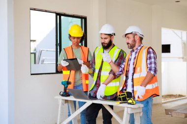 Kapılarda. Profesyonel Makine Mühendisi Ekibi, inşaat sahasının altındaki imalat fabrikasında güvenlik kaskı takıyor..