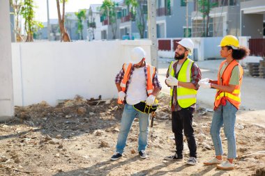 Profesyonel Makine Mühendisi Ekibi, inşaat sahasının altındaki imalat fabrikasında güvenlik kaskı takıyor..