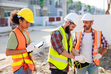 Profesyonel Makine Mühendisi Ekibi, inşaat sahasının altındaki imalat fabrikasında güvenlik kaskı takıyor..
