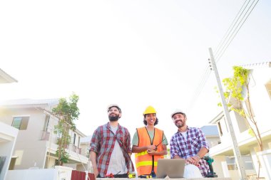 Takım dizüstü bilgisayarda çalışıyor. Profesyonel Makine Mühendisi Ekibi, inşaat sahasının altındaki imalat fabrikasında güvenlik kaskı takıyor..