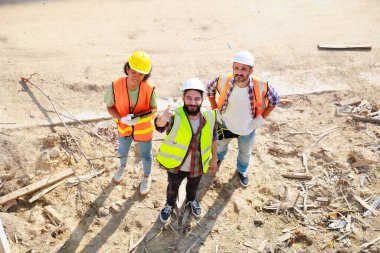 Top view working. Group professional confident Mechanical civil Engineer and construction team at house project underconstruction site. Group portrait. Unity and teamwork concept. 