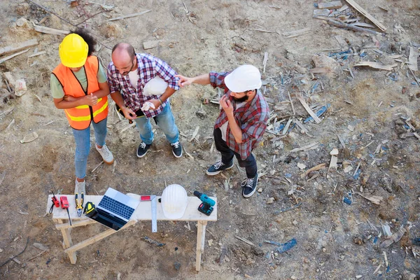 Üst görüntüyü birleştirelim. Başarılı bir takım çalışması birliği. Ev projesinin inşaat alanındaki makine mühendisi ve inşaat ekibi. Eller birleşsin.