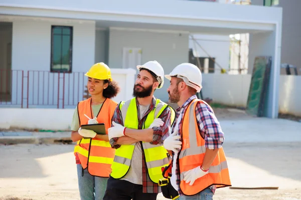 Profesyonel Makine Mühendisi Ekibi, inşaat sahasının altındaki imalat fabrikasında güvenlik kaskı takıyor..