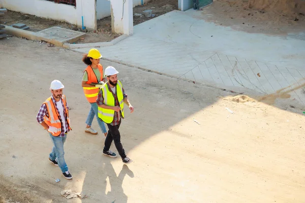 Üst manzara yürüyüşü. İnşaat alanındaki inşaat mühendisi ve inşaat ekibinin kendine güveni tam. Grup fotoğrafı. Birlik ve takım çalışması kavramı. 