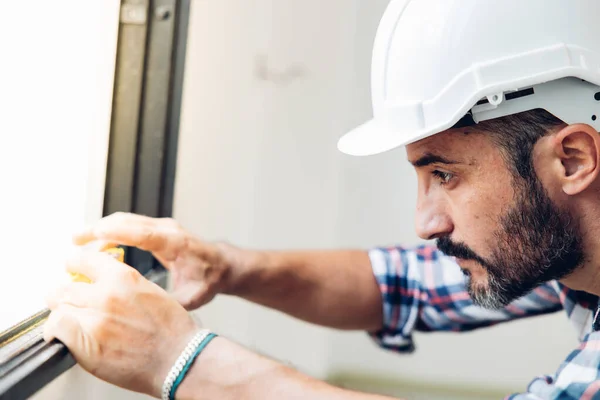 Man Installing Windows New House Construction Site Hispanic Construction Worker lizenzfreie Stockbilder