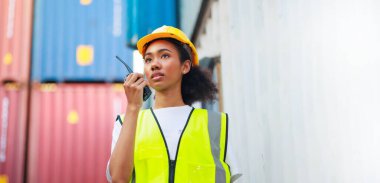 Zenci kadın liman işçisi konteynır kutusunu depo deposundan yüklüyor. Denizci ve uçak sigortası konsepti. Lojistik nakliye sahasında kargo konteynırı kutusu