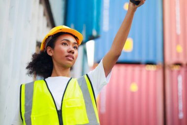 Zenci kadın liman işçisi konteynır kutusunu depo deposundan yüklüyor. Denizci ve uçak sigortası konsepti. Lojistik nakliye sahasında kargo konteynırı kutusu