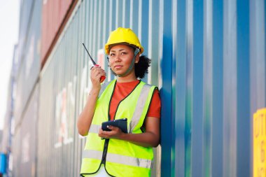 Zenci kadın liman işçisi konteynır kutusunu depo deposundan yüklüyor. Denizci ve uçak sigortası konsepti. lojistik nakliye deposu