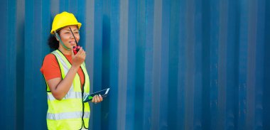 Zenci kadın liman işçisi konteynır kutusunu depo deposundan yüklüyor. Denizci ve uçak sigortası konsepti. lojistik nakliye deposu