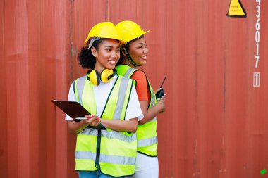 Siyah kadın liman işçisi portresi depo deposundaki kargodan konteynır kutusunu yüklüyor. Denizci ve uçak sigortası konsepti. lojistik nakliye deposu