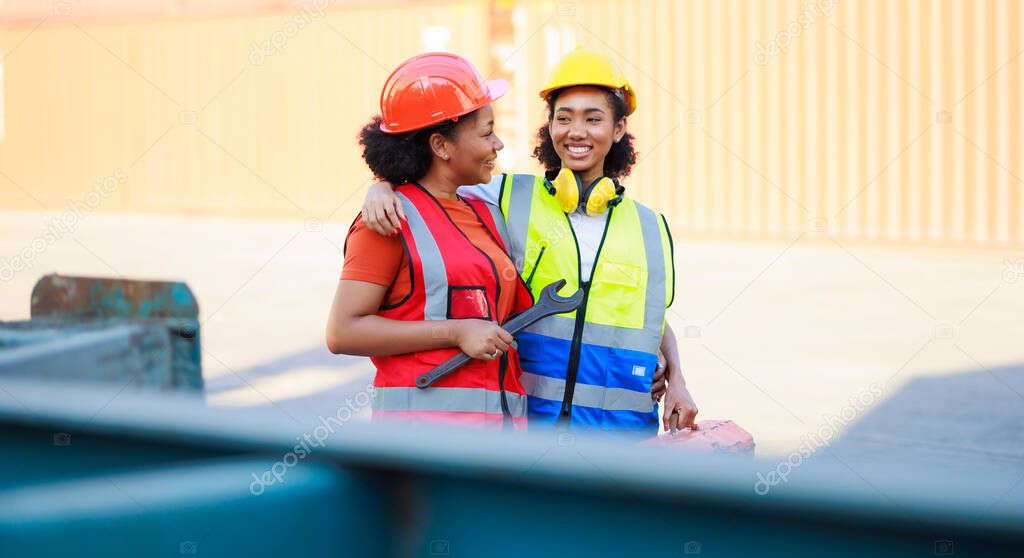 Two African american female mechanic working in car service and maintenance workshop. Mechanical fix car truck warehouse container yard