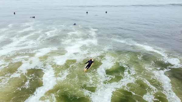Homme mûr pagayant, allongé sur une planche de surf - Homme âgé sportif surfant dans l'océan Pacifique, par une journée ensoleillée avec un ciel bleu et des vagues transparentes. — Photo