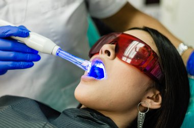 Genç bayan hasta dişçi muayenehanesinde dişçiye gidiyor..