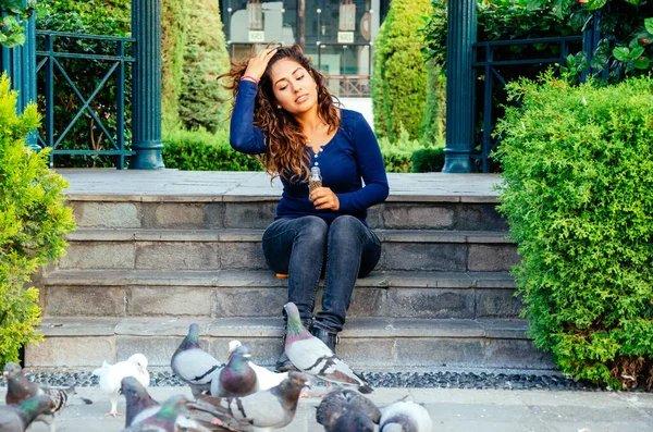 손으로 비둘기에게 먹이를 주는 아름다운 라티나라는 젊은 소녀. — 스톡 사진