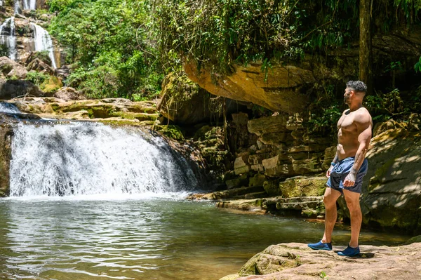Турист, смотрящий на Байозский водопад, в Пуэрто-Юринаки, является одним из самых красивых в Центральных джунглях и регионе Юнин - Перу. Стоковая Картинка