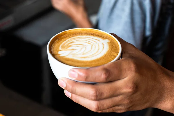 Barista versant du lait pour faire un café latte art. Les gens versent du lait pour faire du café latte art au café ou au café. Photo De Stock