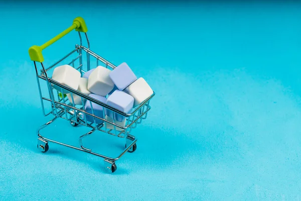 買い物かごの中のキューブ 背景は青 同じ大きさの立方体です — ストック写真