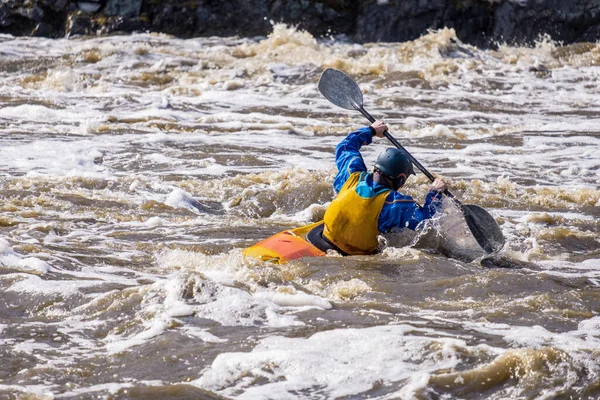 overcoming difficult rifts on the river. kayaking for the strong. a man in a boat who lifted the oar crosses the current