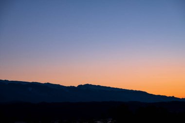 Pembe renkteki dağlarda eğimli bir gökyüzü. Karda dağ zirveleri. Dağlarda gün doğumu