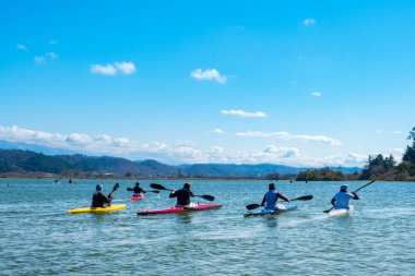 Kanodaki kürekçiler, her biri kendi teknesinde. Bir grup insanın tek bir şeye tutkusu var. Eğlenceli bir tatil. güzel dağ manzarası