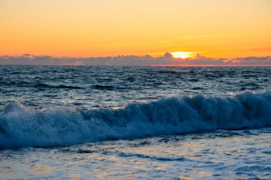 Gün batımında denizde köpüklü bir dalga. Akşamları büyük bir dalga. Denizde alacakaranlık