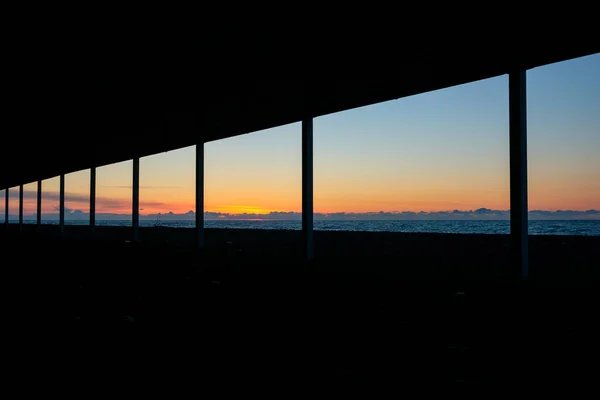 skyline through long window to the sea during sunset. sunset at sea, ribbon of the coast