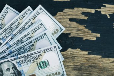 Eski ahşap bir tahtanın üzerinde çok sayıda para, boya ve para soyuluyor.