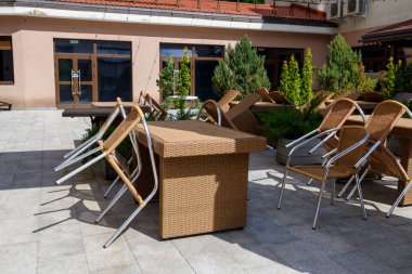 Yazlık kafe boş, sandalyeler masalara yaslanıyor. Kapalı kafe, müşteri yok.