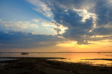 Gün batımında göl üzerinde yoğun bulutlar, gölün doğal manzarası. göl kıyısı ve su