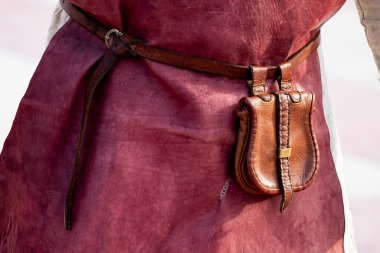 Kırmızı deri işçi önlüğü ve kemerde deri bir çanta. Eski kıyafet tarihi kıyafet üretimi