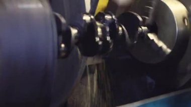 Bir makinenin metal parçasını bilemek, metal parçaları üretmek, metal işleme atölyesinde çalışmak, atölyede çalışmak, torna tezgahında çalışmak, makinede çalışan işçi, metal parçalarını bileyen işçi, metal parçaları işlemek için makine.