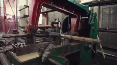 Bir makinenin metal parçasını keskinleştirmek, metali işlemek için bir makine, metal parçasını bileyen bir işçi, metal kesme, bir makine üzerinde çalışan bir işçi, bir elektrik makinesi üzerinde çalışan bir işçi, atölyede çalışan bir işçi, metal işleme