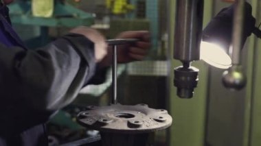 Bir makinenin metal parçasını keskinleştirmek, metali işlemek için bir makine, metal parçasını bileyen bir işçi, metal kesme, bir makine üzerinde çalışan bir işçi, bir elektrik makinesi üzerinde çalışan bir işçi, atölyede çalışan bir işçi, metal işleme