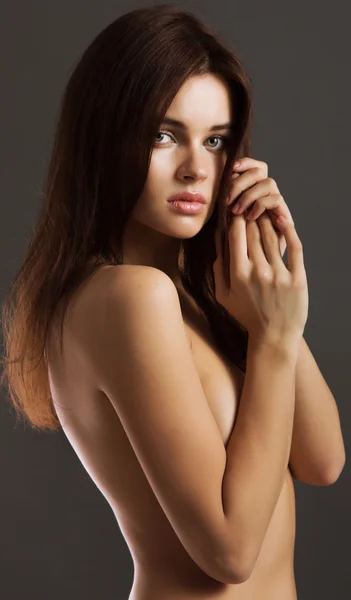 Retrato de una joven desnuda de pie con las manos cubriéndola Imagen de stock