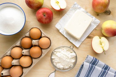 Pastane yatıyordu. Ahşap zemin üzerinde elmalı turta pişirmek için gerekli malzemeler, üst görünüm