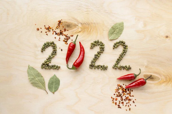 ปีใหม่และแนวคิดคริสต์มาส ข้อความ 2022 ทําจากพริกไทยบนพื้นหลังไม้, มุมมองด้านบน รูปภาพสต็อกที่ปลอดค่าลิขสิทธิ์