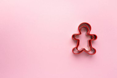 Pembe arka planda insan şeklinde Noel kurabiyesi kesiciler, metin için boşluk