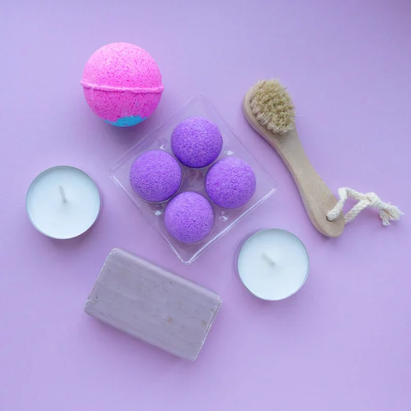 Spa flat lay. Bombas de banho, sabão e escova de massagem em fundo roxo, vista superior — Fotografia de Stock