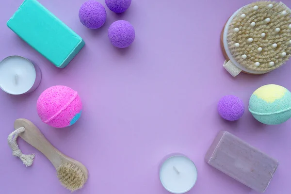 Conjunto de produtos de spa. Bombas de banho, sabão e escovas de massagem em fundo roxo, espaço para texto — Fotografia de Stock