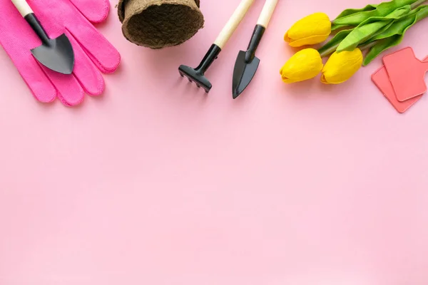 Gartengeräte, Handschuhe und Tulpen auf rosa Hintergrund, Platz für Text — Stockfoto