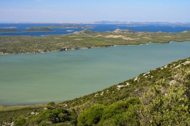 Vrana Gölü üzerindeki Kornati adalarının manzarası (Drage, Hırvatistan), yazın sonlarında güneşli bir gün, mavi gökyüzü