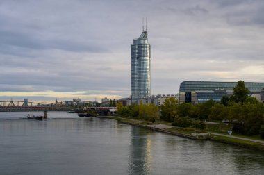 Sonbaharda güneşli bir günde gökdelenli Tuna Nehri (Avusturya))