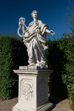 Yazın güneşli bir günde, Belvedere bahçesinde (Viyana, Avusturya) bir müzisyenin heykeli, mavi gökyüzü