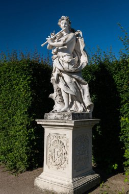 Yazın güneşli bir günde, Belvedere bahçesinde (Viyana, Avusturya) bir müzisyenin heykeli, mavi gökyüzü
