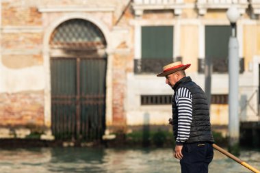 Venedik, İtalya - 29 Ekim 2021 Kışın güneşli bir günde gondolcunun portresi