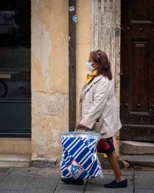 Nancy, Fransa - 2 Eylül 2020: Yüz maskesi takan ve çanta taşıyan kadın