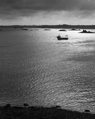 Perros-Guirec, Fransa - 24 Ağustos 2020: Perros Guirec yakınlarında kıyıya demir atan balıkçı teknesi, yazın güneşli, siyah ve beyaz