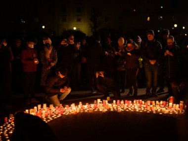 Viyana, Avusturya - 27 Şubat 2022: Ukrayna 'da Heldenplatz' da savaş karşıtı gösteriler düzenleyen insanlar, gece, yerde mum yaktılar